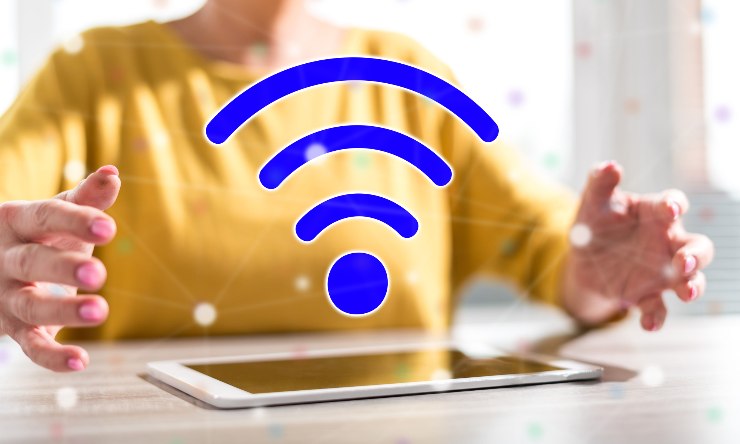 Persona con un tablet e il logo del wifi sopra