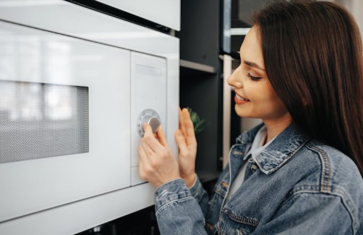 Donna che fa passa cibo al microonde