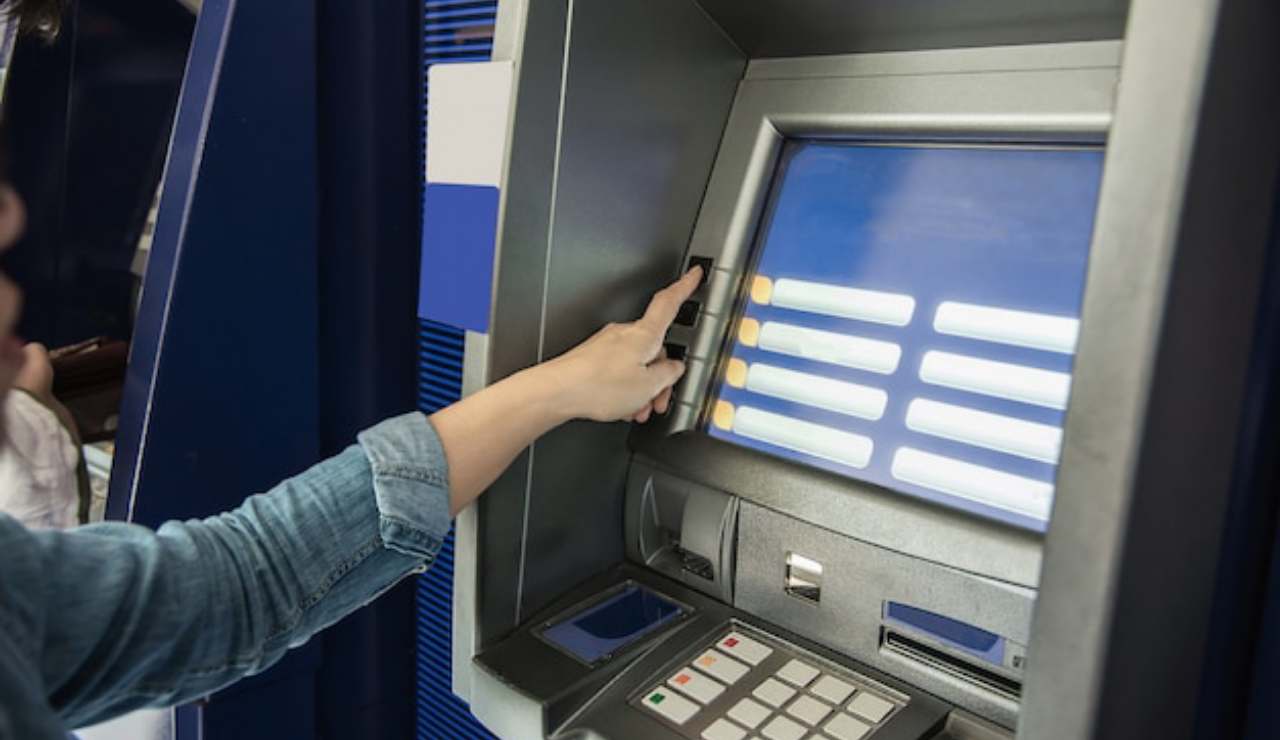 Persona che preleva al bancomat
