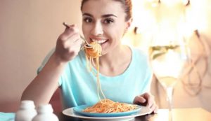 Donna felice mangia pasta (Depositphotos foto) - www.sciencecue.it